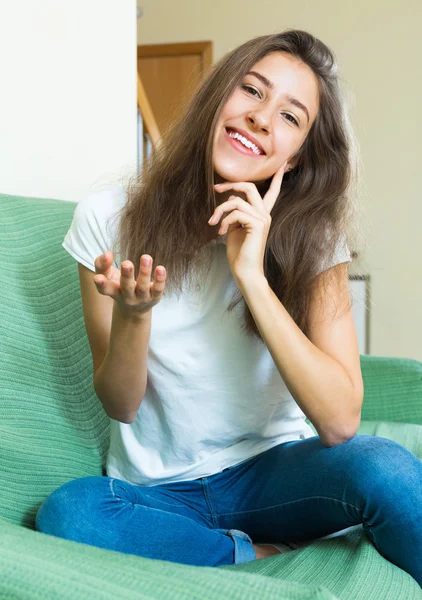 Usmívající se dospívající holka na gauči — Stock fotografie