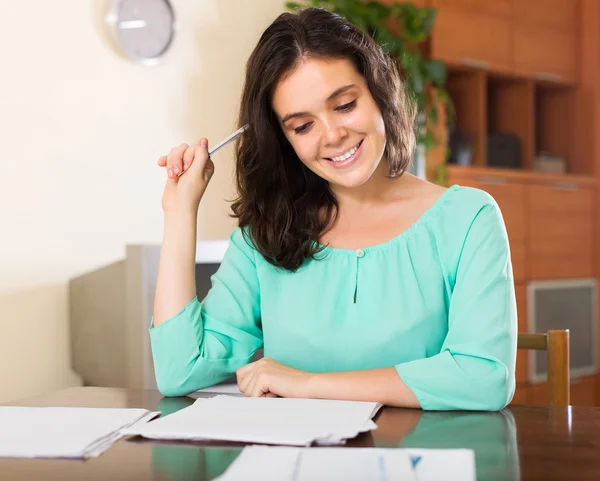 Glückliche brünette Frau liest Dokument — Stockfoto