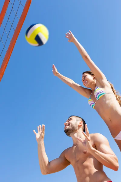 Casal brincando com uma bola e pulando — Fotografia de Stock