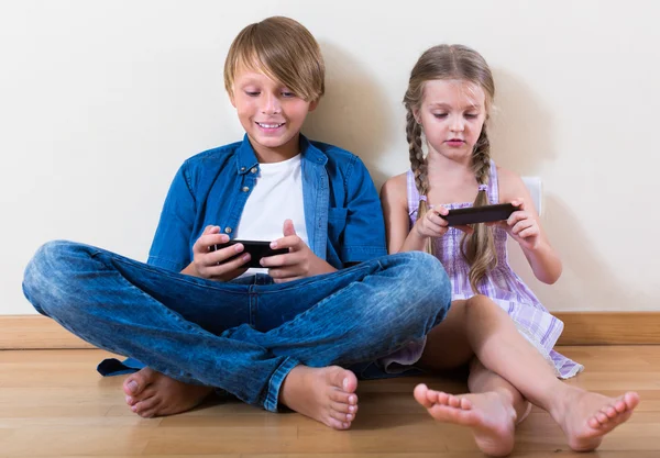 Niños mirando la pantalla de los teléfonos inteligentes —  Fotos de Stock