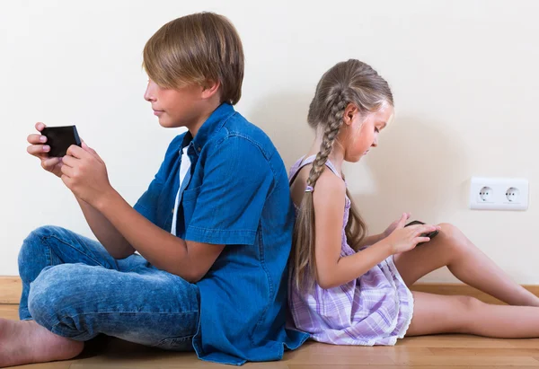 Kinderen begraven in mobiele telefoons — Stockfoto