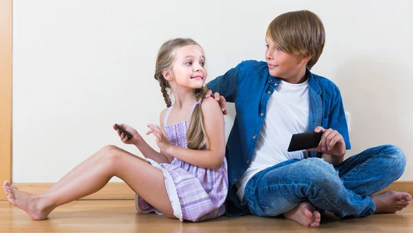 Dziewczyna i chłopak grzebiąc w telefonach komórkowych — Zdjęcie stockowe