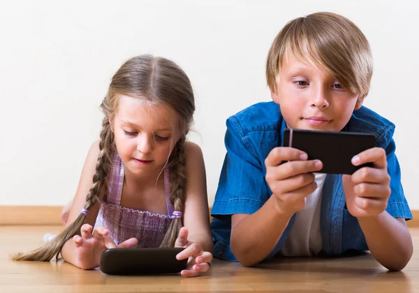 Kinder blicken auf Bildschirm von Smartphones — Stockfoto