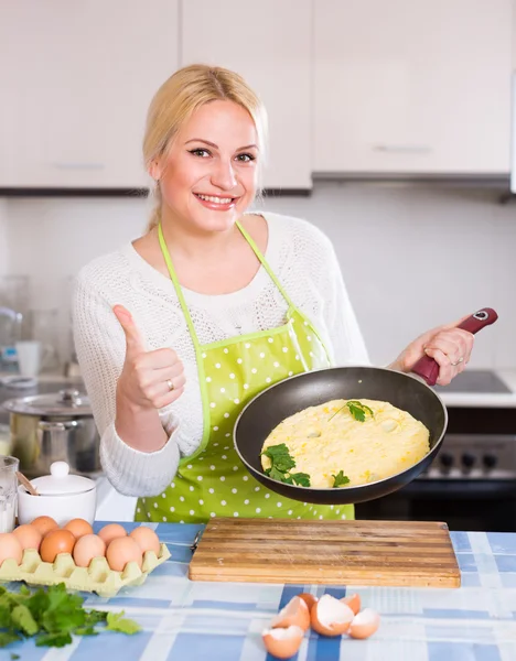 Donna sorridente che fa omelette — Foto Stock