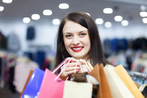 Mujer con bolsas de compras en la tienda de moda —  Fotos de Stock