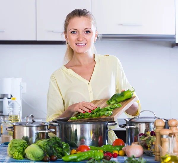 Ama de casa cocinar verduras en la cocina — Foto de Stock