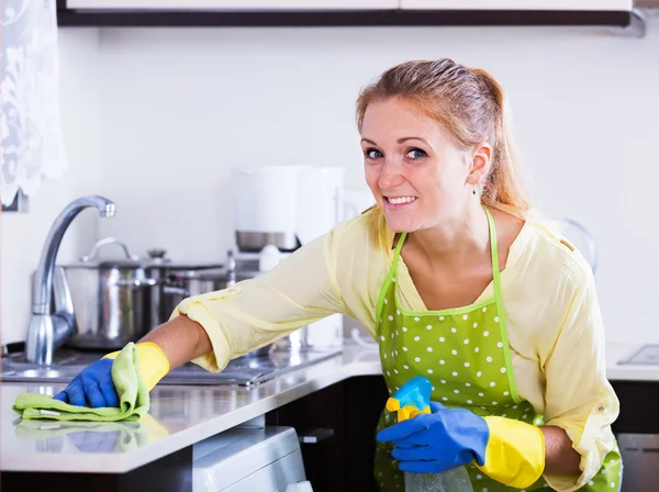 Vrouw afstoffen keuken top thuis — Stockfoto