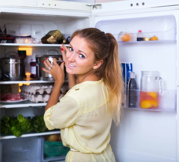 Vrolijk meisje zoeken in koelkast — Stockfoto