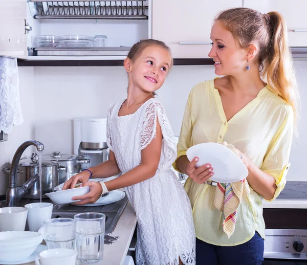 Woman and girl washing dishes — Stock Photo, Image