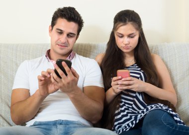 spouses playing with smartphones  clipart
