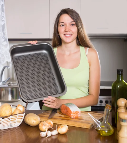 Glimlachend huisvrouw koken zalm — Stockfoto