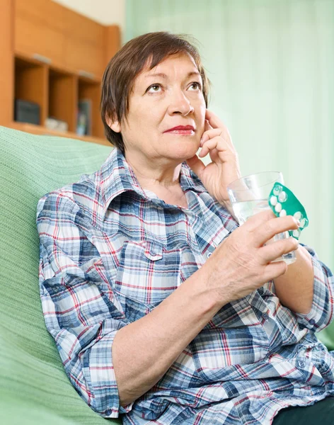 Серйозна жінка-пенсіонерка з таблетками — стокове фото