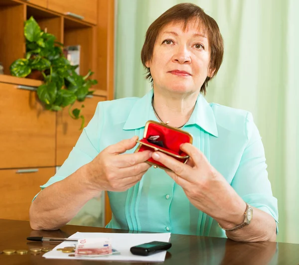 Frau schaut besorgt auf Geld — Stockfoto