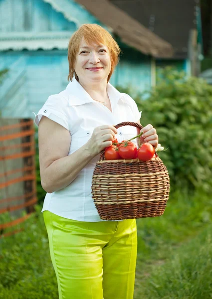 Femme mûre avec des tomates — Photo