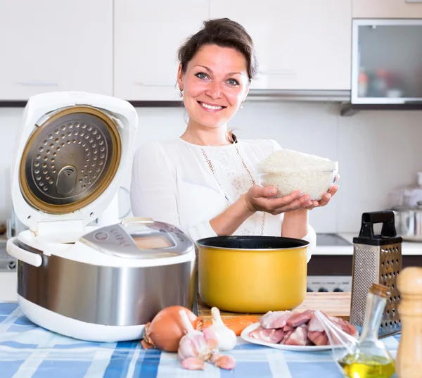 Mujer cocinando pilaf en multicooker — Foto de Stock