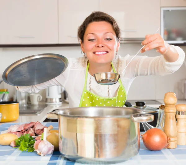 Mulher que cozinha sopa com carne — Fotografia de Stock