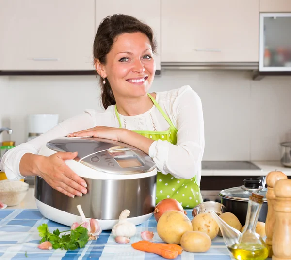 Çoklu pişiriciyle yemek pişiren kadın — Stok fotoğraf