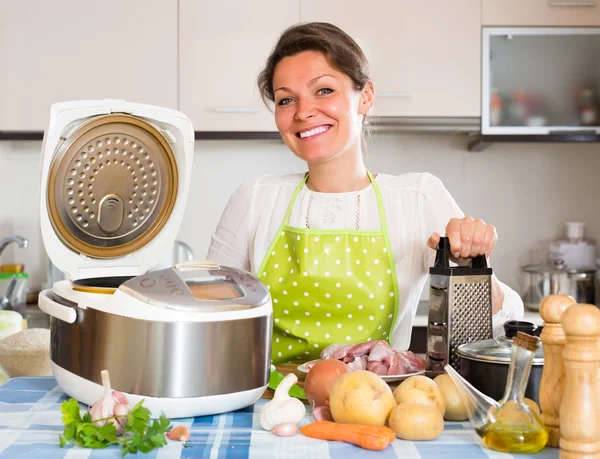 Çoklu pişiriciyle yemek pişiren kadın — Stok fotoğraf