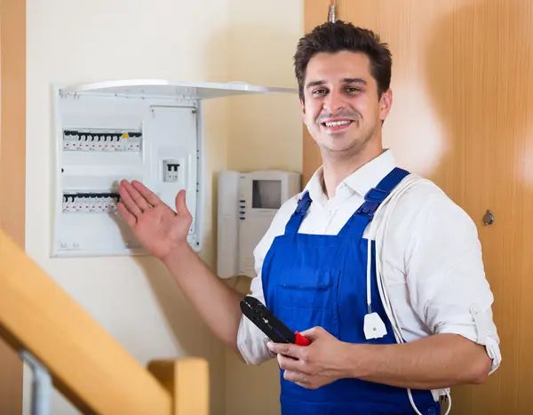 Electrician checking electric automatic control panel at home Stock Image