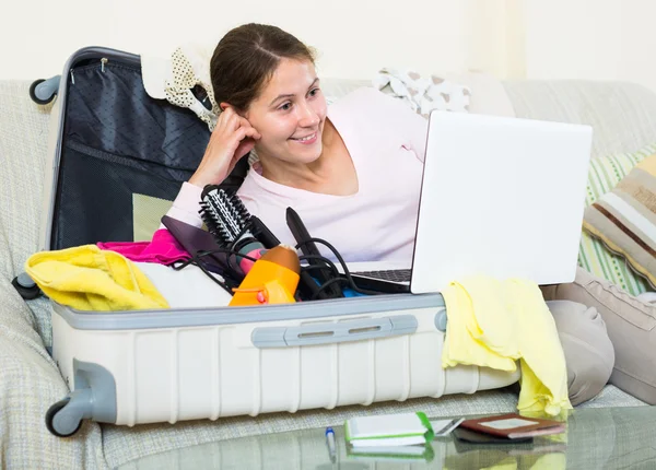 Brunette planning vakantie met laptop — Stockfoto