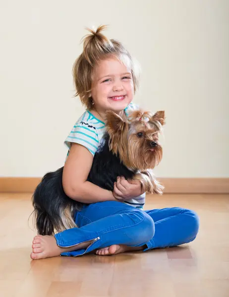 Söt liten flicka med yorkshire terrier inomhus — Stockfoto