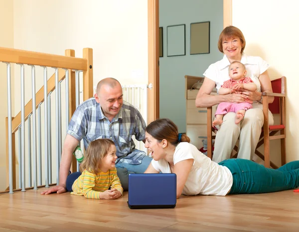 Família feliz com laptop em casa — Fotografia de Stock