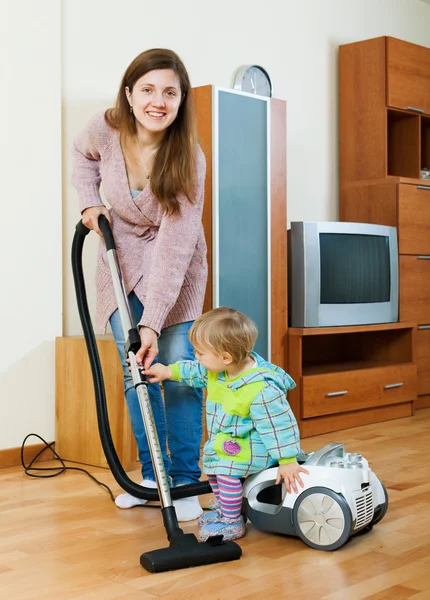 Femme avec un tout-petit faisant le nettoyage de la maison — Photo