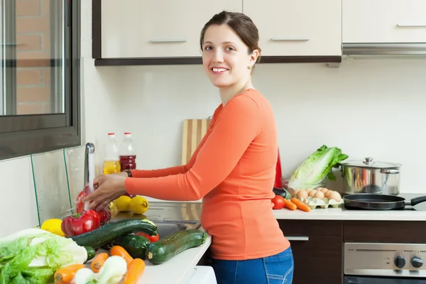 Femme heureuse laver les légumes frais — Photo