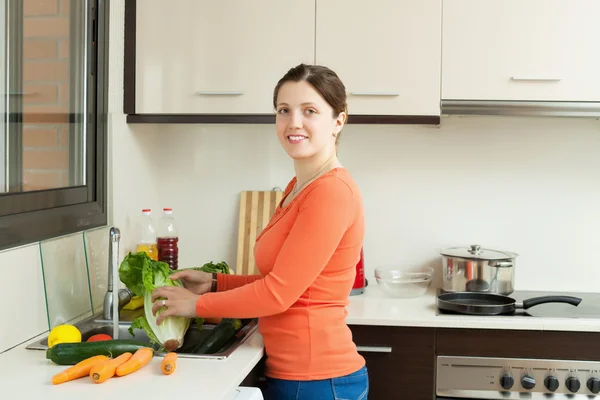 Glimlachend huisvrouw wassen groenten — Stockfoto