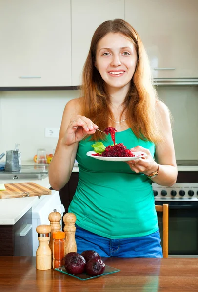 Tjej äter kokta rödbetor på kök — Stockfoto