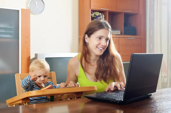 Mulher trabalhando com laptop e bebê — Fotografia de Stock