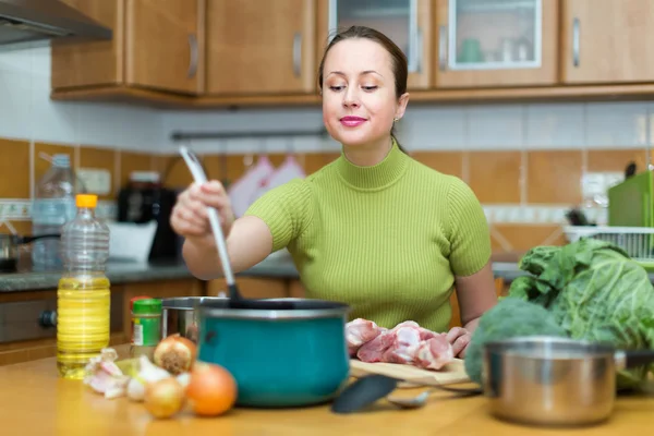 Ama de casa cocina en la cocina —  Fotos de Stock