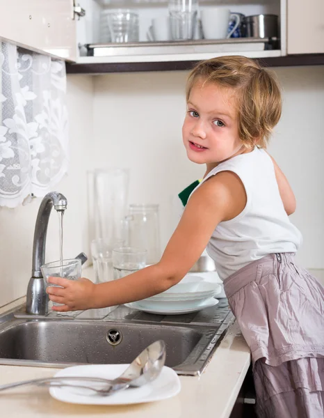 Baby girl washing dishes Stock Picture