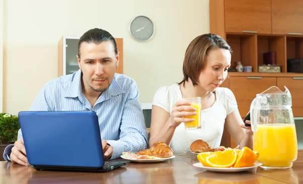 Pareja casual utilizando dispositivos electrónicos — Foto de Stock