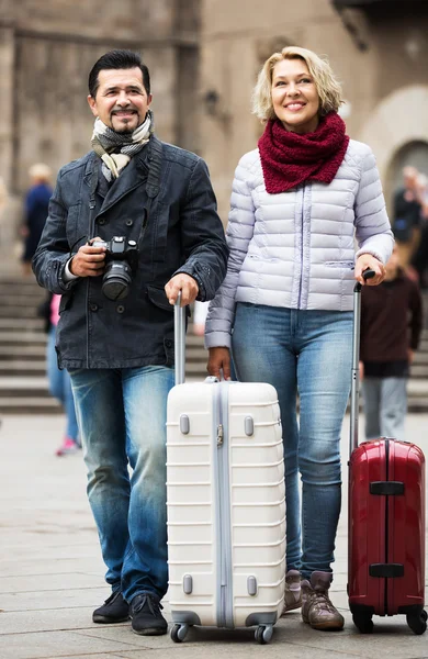Casal maduro andando com bagagem — Fotografia de Stock