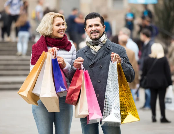 Casal andando e levando sacos de compras — Fotografia de Stock