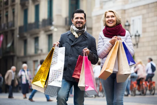 Casal andando e levando sacos de compras — Fotografia de Stock