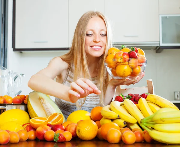 Dona de casa com frutas na cozinha doméstica — Fotografia de Stock
