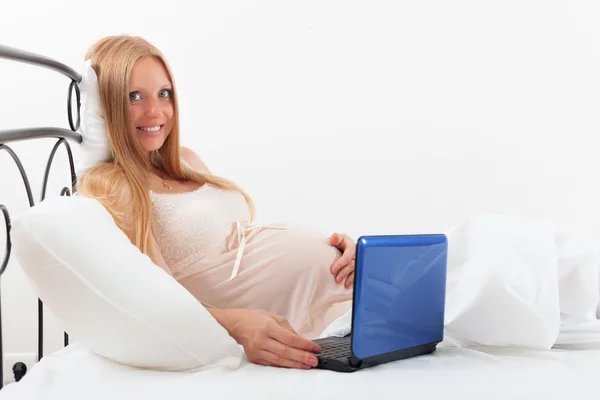 Mulher grávida em camisola com laptop — Fotografia de Stock