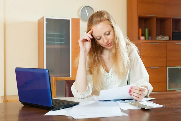 Ernstige blonde vrouw financiële documenten lezen — Stockfoto