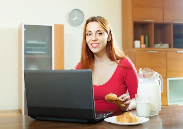 Frau benutzt Laptop beim Frühstück — Stockfoto