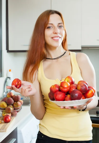 Souriante fille aux cheveux longs avec nectarines — Photo