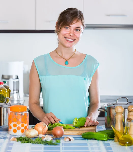 Dívka v kuchyni kastrol a zeleniny — Stock fotografie