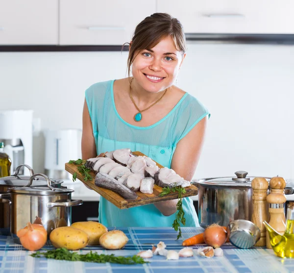 Hausfrau mit merluccius-Fischscheiben — Stockfoto