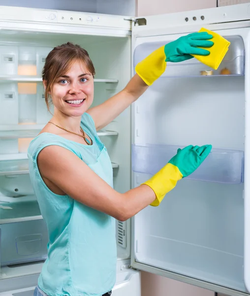 Dona de casa de lavar geladeira com detergente — Fotografia de Stock