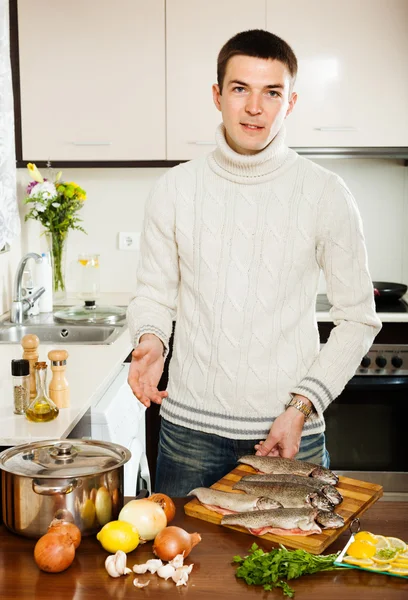 Człowiek z pstrąga w kuchni — Zdjęcie stockowe