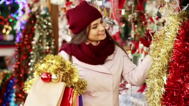 Женщина выбирает украшения на Рождество — стоковое видео