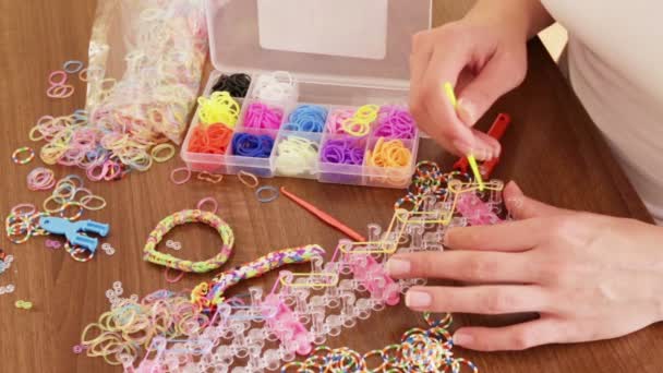 Meisje maakt decoratieve armband — Stockvideo