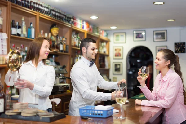 Frau steht mit Glas Wein an Bar — Stockfoto