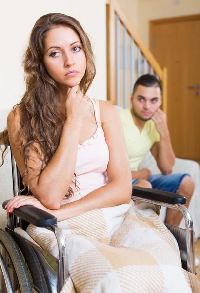 Sad man with girlfriend in invalid chair — Stock Photo, Image